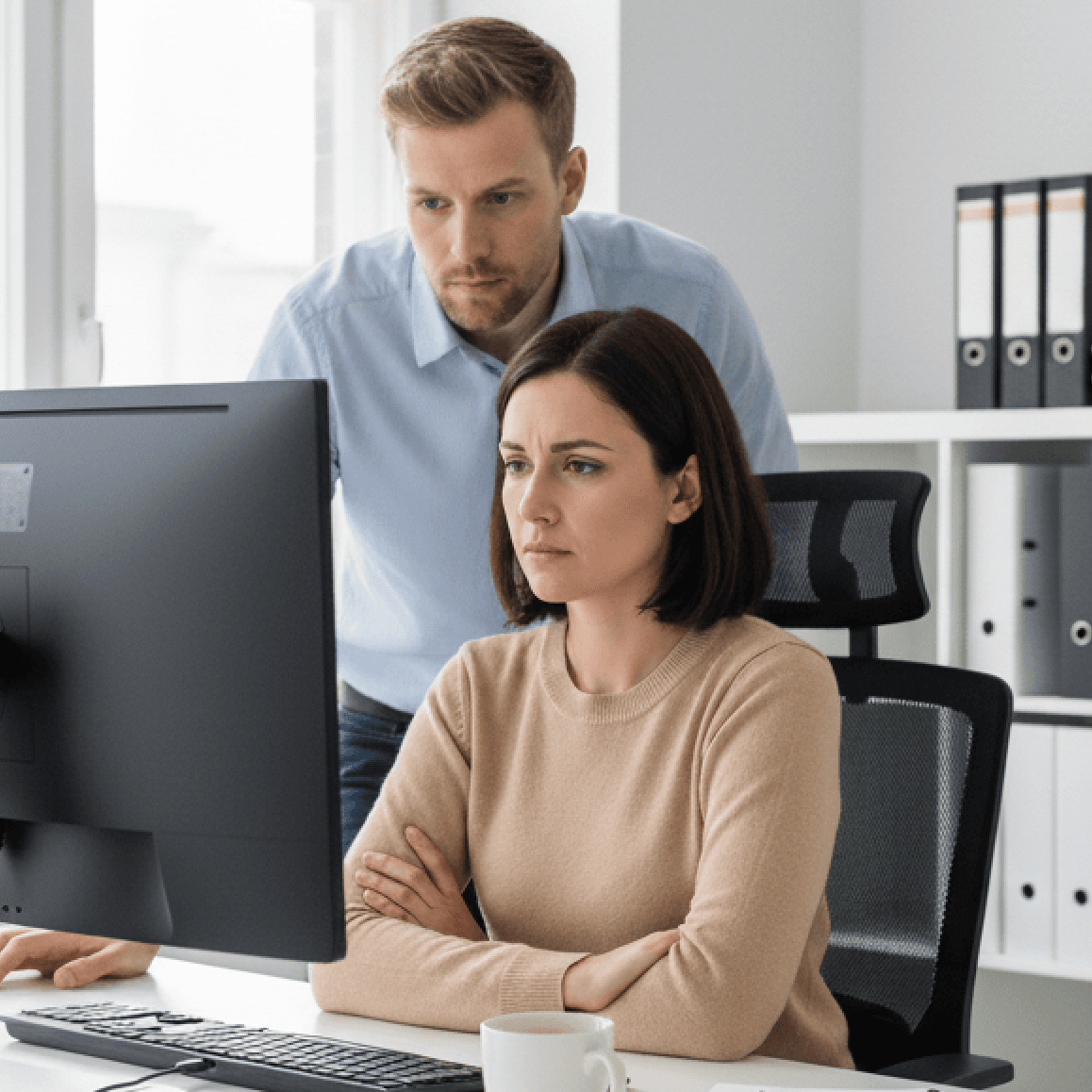 Muž a žena v kanceláři sledují monitor a přemýšlejí, proč jejich web nefunguje podle očekávání